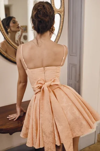 Rosalinda perzikkleurige jacquard mini-jurk met strikken